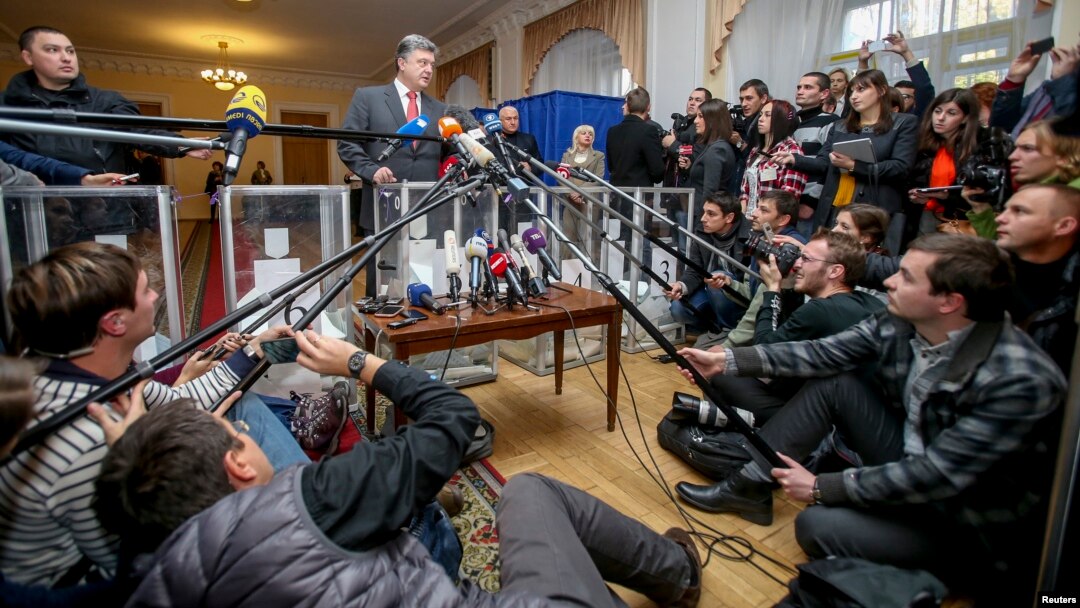 Ukrainian President Petro Poroshenko (center) talks to the media as he visits a polling station during parliamentary elections in Kyiv on October 26. 