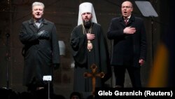 Ukrainian President Petro Poroshenko (left), parliamentary speaker Andriy Parubiy (right), and the newly elected head of the independent Ukrainian Orthodox Church, Metropolitan Epifaniy, sing the national anthem at St. Sophia's Cathedral in Kyiv on December 15.