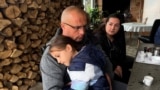 Jablanica, Bosnia -- An evacuee from the flooded areas with his child