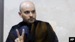 Andrei Pivovarov gestures from behind the glass during a court hearing in Krasnodar on June 2.