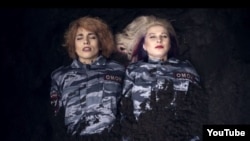 The single-take video shows group members Nadezhda Tolokonnikova and Maria Alyokhina clad in Russian riot-police uniforms and being buried alive.