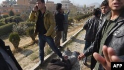 An Afghan intelligence officer places his foot on a man suspected of planting explosives that caused a blast with no casualties in the Wazir Akbar Khan area of Kabul on November 25, two days before the most recent attack. 