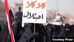 Female supporters of Muqtada al-Sadr march in Baghdad in May, with one holding a sign saying, "No, No to the Occupation!"