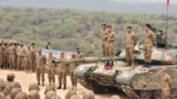Shefi i ushtrisë pakistaneze, gjenerali Syed Asim Munir duke qëndruar mbi një tank dhe duke folur me trupat e ushtrisë.