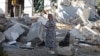 A woman talks on a mobile phone next an industrial building damaged after a Russian attack in the Odesa region in southern Ukraine on September 25.