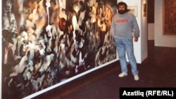 Uzbek artist Vyacheslav Akhunov in London in the late 1980s with his painting showing the Red Army’s 1920 attack on Bukhara. (file photo)