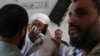 PAKISTAN -- People comfort a cleric who mourns over lost of his students at the site of a bomb explosion in an Islamic seminary, in Peshawar, Pakistan, Tuesday, Oct. 27, 2020