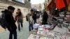 Iranians look at newspapers displayed on the ground outside a kiosk in a street of Tehran, Iran, 24 November 2013.