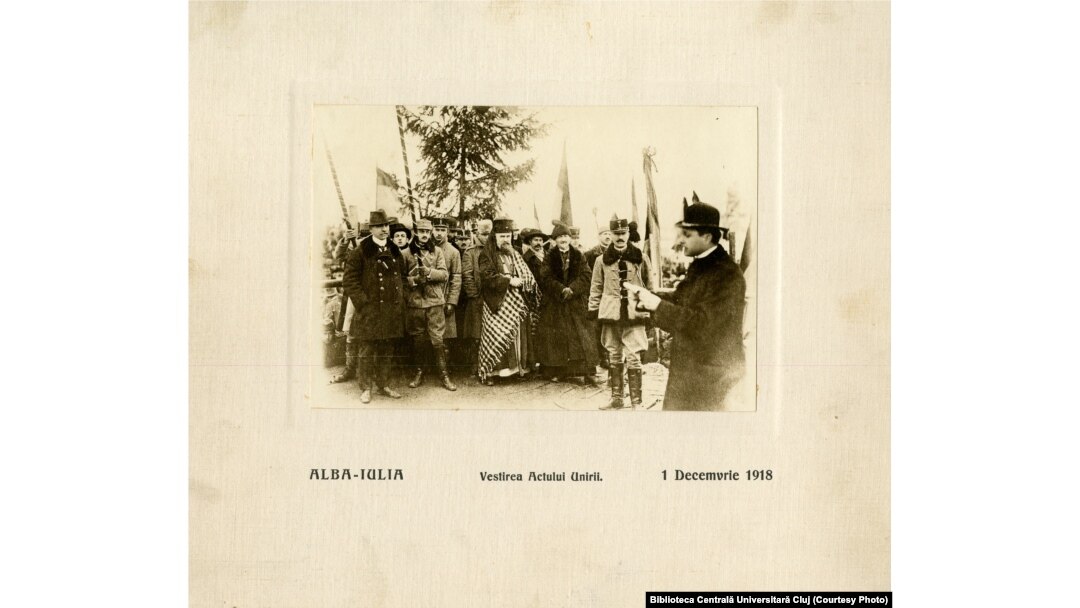 1 Decembrie 1918, Alba-Iulia. Episcopul greco-catolic, Iuliu Hossu, citind Proclamația de Unire a Transilvaniei cu Regatul României în fața mulțimii. În imagine apare și mitropolitul ortodox, Miron, viitorul Patriarh al României Unite.