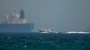 An Emirati coast guard vessel passes an oil tanker off the coast of Fujairah, May 13, 2019