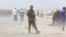 A member of Iraqi Kurdish security forces stands guard as families fleeing violence in the city of Mosul wait at a checkpoint in outskirts of Irbil on June 10.