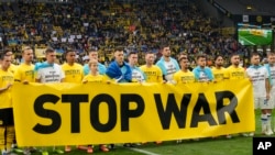 Players hold up a banner prior to a charity soccer match between Bundesliga team Borussia Dortmund and Dynamo Kyiv of Ukraine in Dortmund, Germany, on April 26.