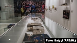 Fletore dhe libra të fëmijëve të vrarë gjatë luftës të paraqitura në ekspozitën "“Na Ishte Njëherë Që Kurrë Mos Qoftë”. (Foto: Radio Evropa e Lirë)