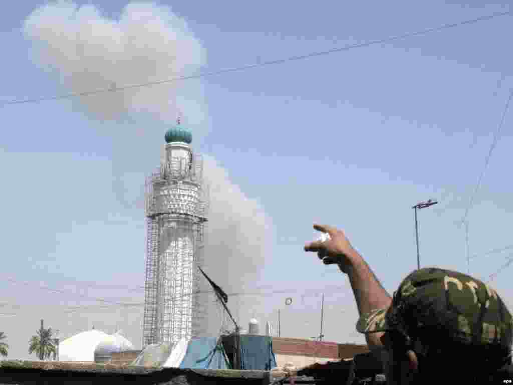 Ministarstvo spoljnih poslova - Irak - Čovek pokazuje u pravcu zgrade iračkog Ministarstva spoljnih poslova u Bagdadu iz koje kulja dim nakon eksplozije kamiona bombe 19. avgust 2009. 