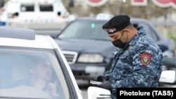 ARMENIA -- A police officer checks a driver's documents during a coronavirus lockdown as a preventive measure against coronavirus disease, in Yerevan, April 2, 2020