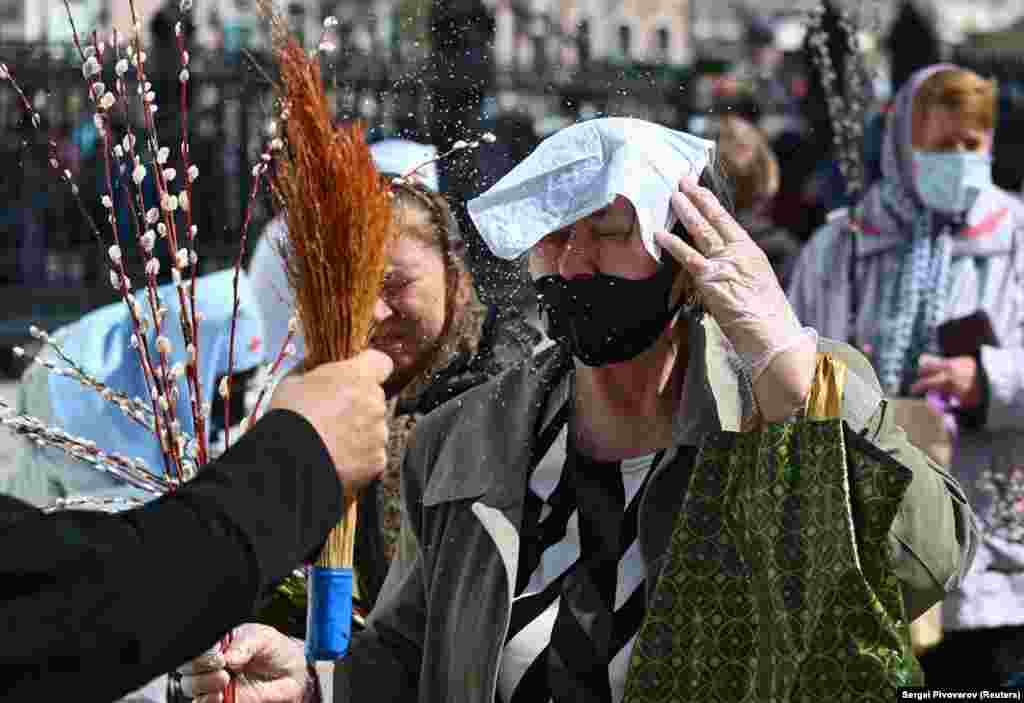 Russian Orthodox believers are sprayed with holy water during a service marking the feast of Palm Sunday amid the coronavirus pandemic in Rostov-on-Don on April 25. (Reuters/Sergey Pivovarov)