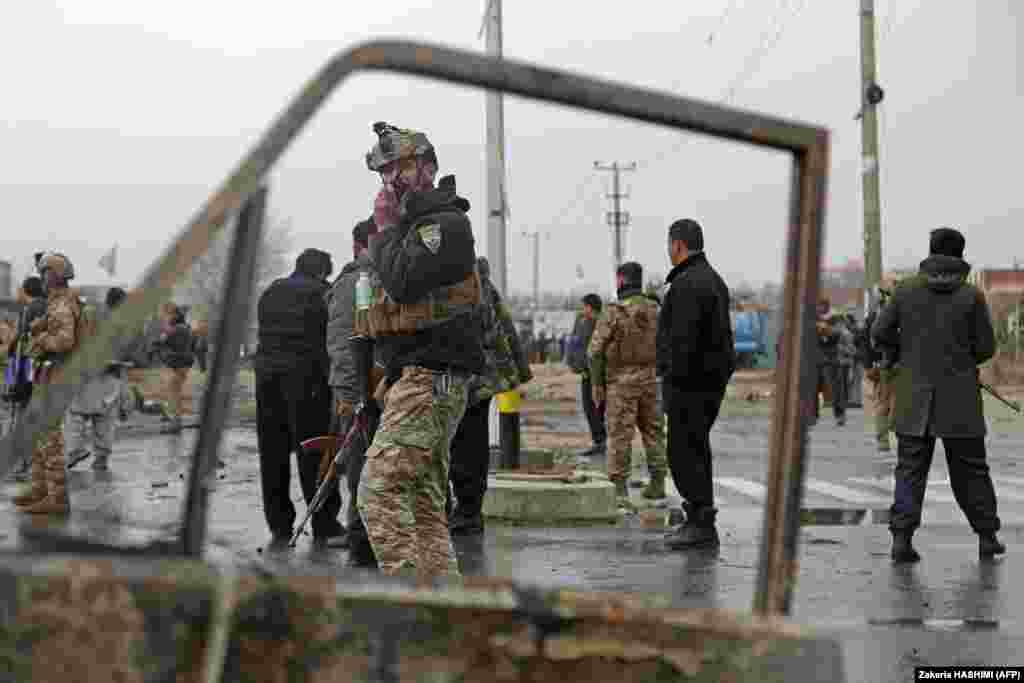 Members of the Afghan security forces stand guard at the site of an attack in Kabul on December 20.