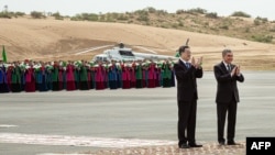 Türkmenistanyň öňki prezidenti Gurbanguly Berdimuhamedow (sagda) we Hytaýyň wise-premýeri Ding Xuexiang Aşgabatdan 400 km gündogarda ýerleşýän Galkynyş gaz känindäki ösüş taslamasynyň meýilleşdirilen ýedi tapgyrynyň dördünjisiniň işe giriziliş dabarasynda el çarpýarlar. (arhiw)