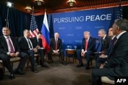 Президент США Дональд Трамп (у центрі праворуч) і президент Росії Володимир Путін (у центрі ліворуч) зустрічаються в присутності делегацій на Алясці, 15 серпня 2025 року