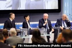 Premierul moldovean, Alexandru Munteanu (al doilea din dreapta), vorbește la un forum privind extinderea UE. În stânga sa - comisara pentru extindere, Marta Kos, în dreapta - comisarul pentru apărare și spațiu, Andrius Kubilius. Bruxelles, 18 noiembrie 2025.