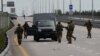 Mercenarii din grupul Wagner înconjoară un vehicul oprit pe autostrada M-4, care leagă Moscova de orașele din sudul Rusiei, 24 iunie.