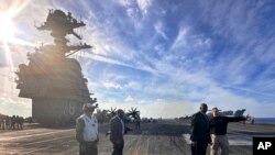 وزیر دفاع آمریکا (نفر دوم از راست) بر روی عرشه ناو هواپیمابر جرالد فورد که برای جلوگیری از گسترش جنگ غزه به دریای مدیترانه اعزام شده است