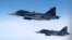 Swedish Air Force Saab JAS 39 Gripen fighter jets fly alongside an aircraft simulating aerial interceptions during a NATO media day on July 4.