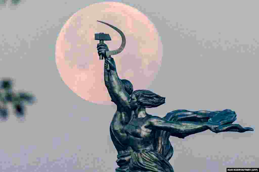 The full moon is pictured behind the Worker and Kolkhoz Woman statue in Moscow. (AFP/Kirill Kudryavtsev)