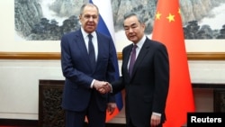 Russia's Foreign Minister Sergei Lavrov (left) shakes hands with China's Foreign Minister Wang Yi during a meeting in Beijing on April 9.