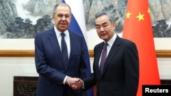 Russian Foreign Minister Sergei Lavrov (left) meets with Chinese Foreign Minister Wang Yi in Beijing on April 9.