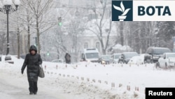 Një grua ecën nëpër rrugët e mbuluara me borë në Kiev të Ukrainës më 15 janar 2026. 