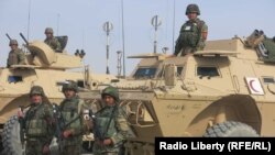 سربازان افغان در کنار تجهیزات آمریکایی هدیه شده به ارتش آمریکا در قندهار در فوریه ۲۰۱۵