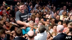 Igor Vovkovinsky (the tall one in the picture) shakes hands with U.S. President Barack Obama (center) at a political rally in Minnesota. 