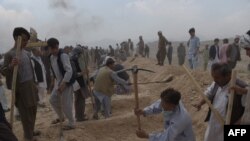 Men dig graves for victims of the July 23 attack in Kabul.