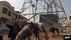 Pakistani workers complete a high-voltage power pole in Rawalpindi. (file photo)