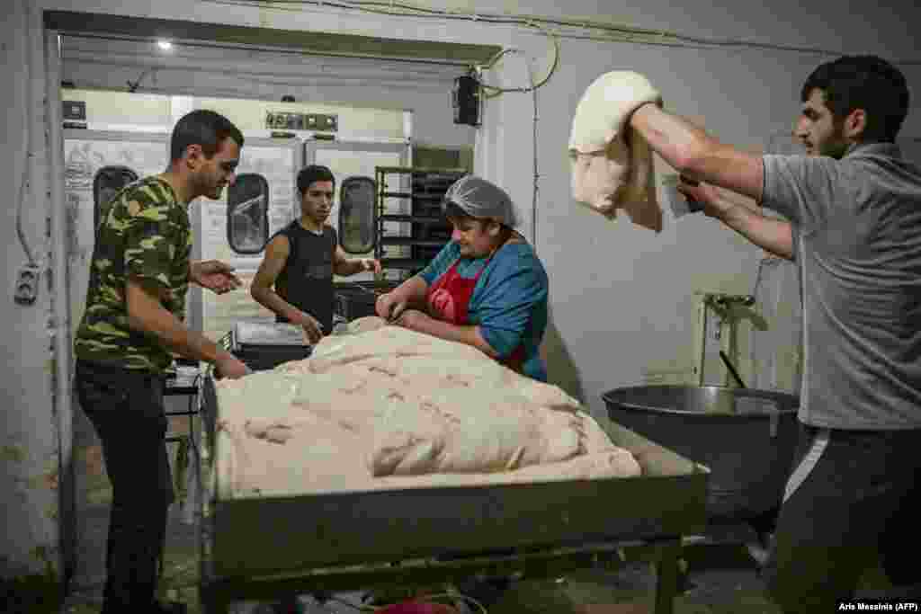 Рабочие пекарни в Степанакерте готовят тесто для хлеба. Владельцы предприятия, этнические армяне, бесплатно раздают 700-граммовые буханки оставшимся в городе жителям.