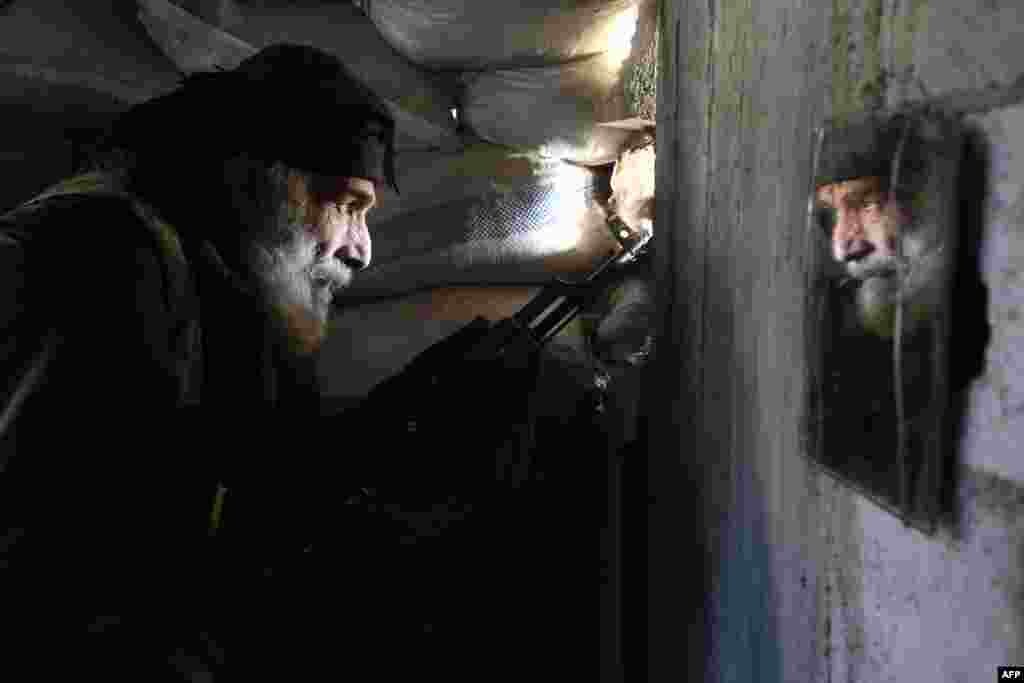 A Syrian rebel fighter holds a position inside a building on the front line near Damascus on February 5. (AFP/Amer Almohibany)