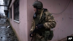 A Ukrainian serviceman prepares to change position during a patrol in the frontline city of Vuhledar on February 25. 