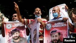 Demonstranti drže slike palestinskog zatvorenika koji je štrajkao glađu Maher Al-Akhras, kojeg drži Izrael, tokom skupa solidarnosti u Gazi 12. oktobra 2020.