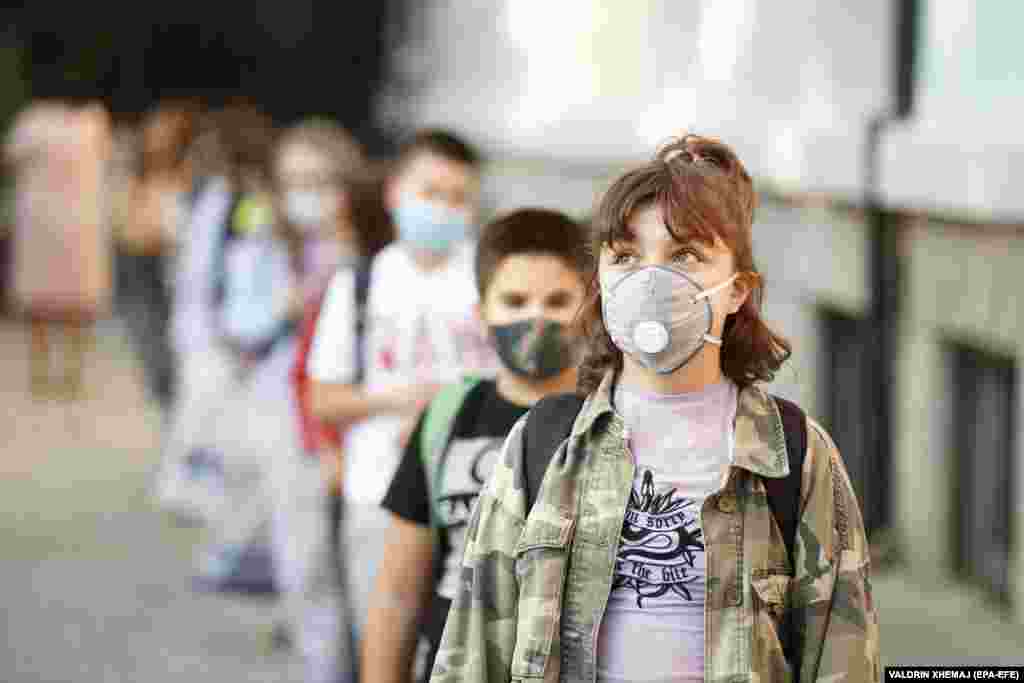 Elementary-school students wearing face masks keep their distance on the first day of school in Pristina, Kosovo.