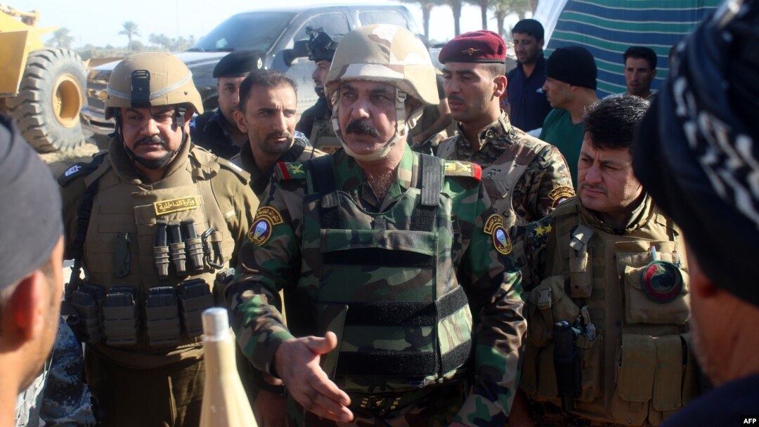 Iraqi Major General Kadhem Mohammed al-Fahdawi (center), the new Anbar police chief, speaks to pro-government fighters in Amriyat Al-Fallujah, 30 kilometers south of Fallujah, on October 23.
