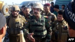 Iraqi Major General Kadhem Mohammed al-Fahdawi (center), the new Anbar police chief, speaks to pro-government fighters in Amriyat Al-Fallujah, 30 kilometers south of Fallujah, on October 23.