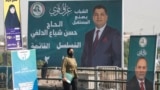 A woman walks past campaign posters ahead of Iraq's parliamentary elections in Sadr City, east of Baghdad, on October 29.
