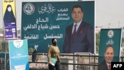 Një grua kalon pranë bilbordeve për zgjedhjet parlamentare në Irak. Bagdad, 29 tetor 2025.
