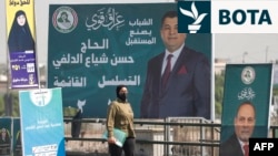 Një grua kalon pranë bilbordeve për zgjedhjet parlamentare në Irak. Bagdad, 29 tetor 2025. 
