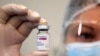 GEORGIA -- A health worker holds a vial containing the AstraZeneca vaccine against COVID-19 used at the Infectious Diseases, AIFS and Clinical Immunology Research Center in Tbilisi, March 15, 2021