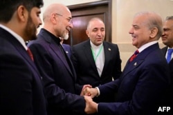 Pakistan's Prime Minister Shehbaz Sharif (second right) with Foreign Minister Mohammad Ishaq Dar (right) greets Iran's parliamentary speaker, Mohammad Baqer Qalibaf on April 11.