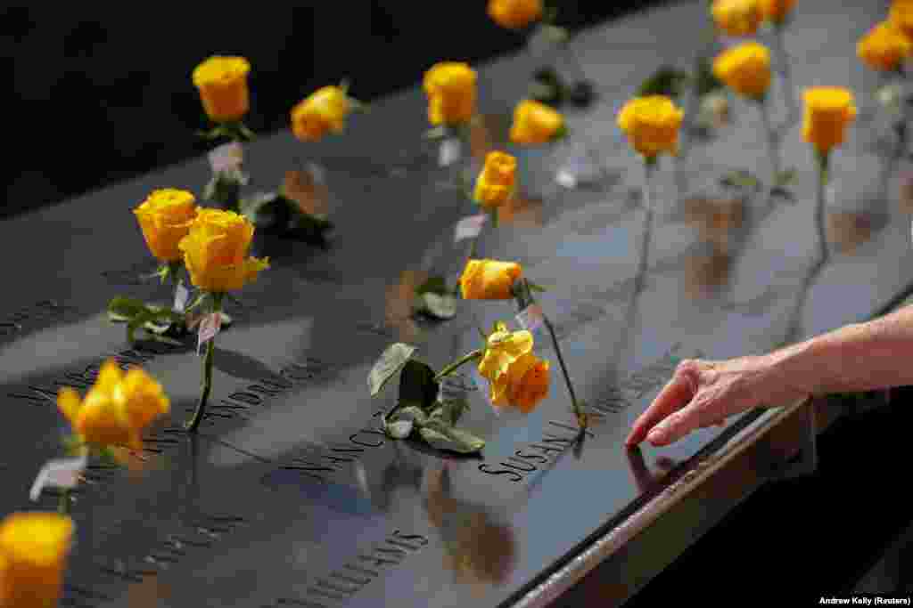 Lule të vendosura pranë emrave të viktimave në vendin përkujtimor dhe muzeun kombëtar të 11 Shtatorit, një muaj para njëzetvjetorit të sulmeve të vitit 2001. (Menhetën, Nju-Jork, 11 gusht 2021)