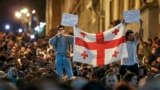 Demonstrators hold a Georgian national flag as they protest against a controversial "foreign agents" bill outside the parliament in Tbilisi on April 17.