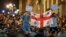 Demonstrators hold a Georgian national flag as they protest against a controversial "foreign agents" bill outside the parliament in Tbilisi on April 17.